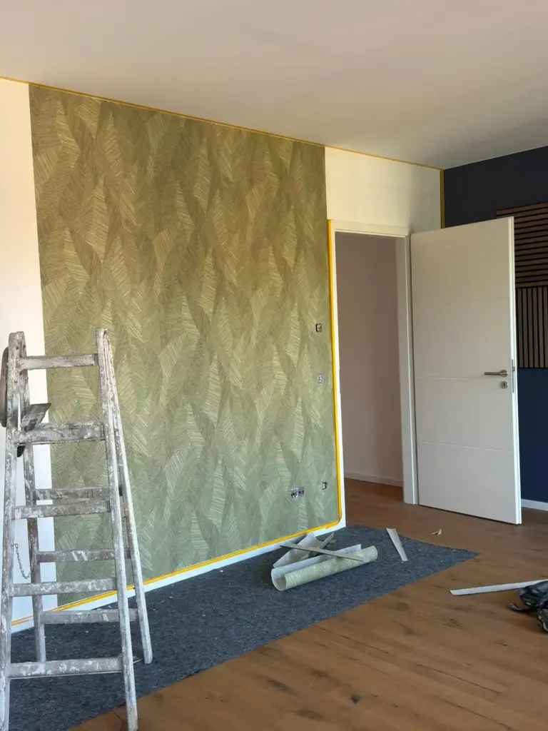 Ein Raum mit grüner Mustertapete beim Innenausbau durch RoGi-Bau.