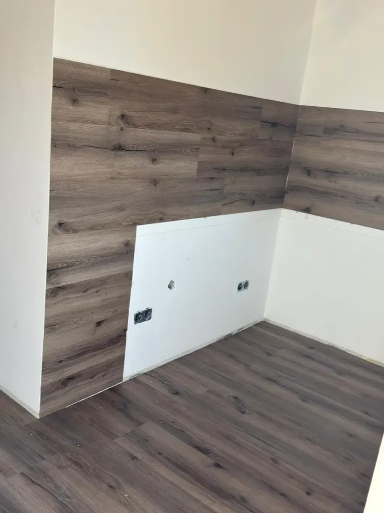 Eine frisch renovierte Küchennische mit Holzpanels, umgesetzt von RoGi-Bau.