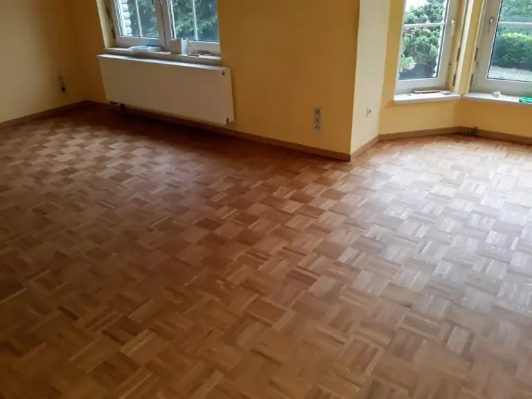 Frisch verlegter Laminatboden in Holzoptik in einem hellen Raum, verlegt von RoGi-Bau.