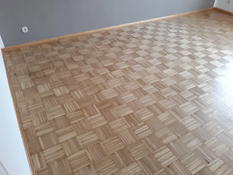 Frisch verlegter Laminatboden in Holzoptik in einem hellen Raum, verlegt von RoGi-Bau.