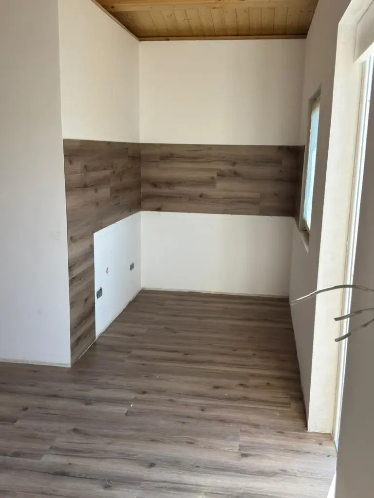 Eine frisch renovierte Küchennische mit Holzpanels, umgesetzt von RoGi-Bau.