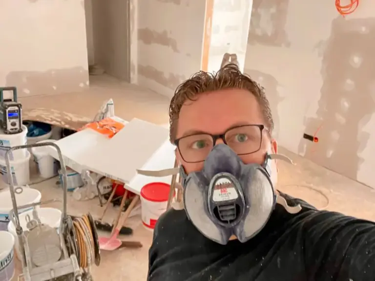 Ronny Giebel, Inhaber von RoGi-Bau, mit Gasmaske auf einer Innenausbaubaustelle.