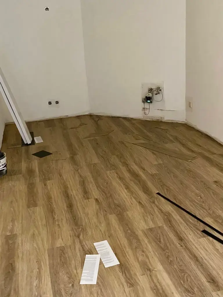 Frisch verlegter Laminatboden in einem Zimmer mit weißen Wänden, umgesetzt von RoGi-Bau.